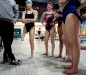 Elizabeth listens to her Rapids Area YMCA coach, Nathan Manley, left, during a Friday night practice with the second swim team she is on, the RAYS. \