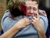 Marissa Neely, 18, clutches a friend after learning that a fourth body was found in a Wright Township home that burned down earlier that morning. Char Zimmer and her two sons, Tyler, 17, and Jeremy, 20, were also lost in the fire. Coopersville High School students and other family friends gathered outside the home after learning the news.