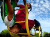 From left, Michael Davis, 7, of Grand Rapids and his sister Janaesha Glasco, 10, climb on the monkey bars at Riverside Park. Warm weather drew many to the park for playing, lounging, and chasing geese.
