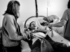 In-home LPN nurse Char Sanok, right, and close friend Rachel Crooks work together to lift Hoffman out of bed while getting ready for the day. Crooks is training to be a nurse herself. \