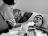 Hoffman cringes as in-home nurse Char Sanok suctions fluid from his lungs, a process he must go through several times a day. (Emily Zoladz | The Grand Rapids Press)